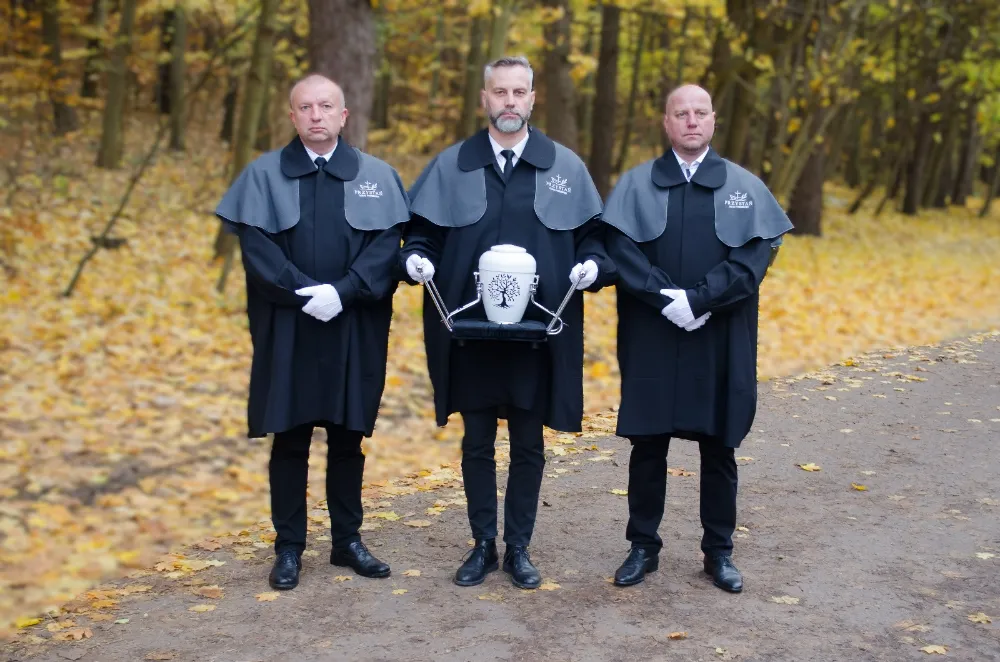 Obsługa pogrzebu niesie urnę. Przystań zakład pogrzebowy oferuję kompleksową obsługę pogrzebów wraz z kremacją w Gdańsku.